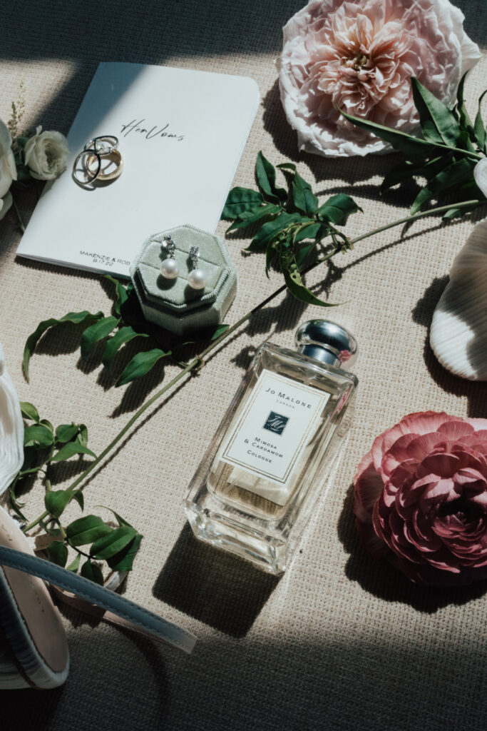 Full Service Planning and Design wedding details featuring rings, pearl earrings, a vow book, florals, and elegant bridal accessories.