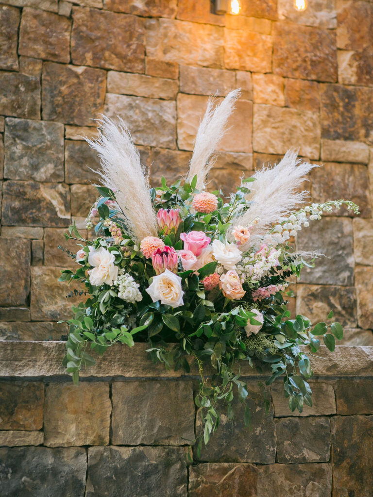 planning-a-destination-wedding-in-new-england beautiful floral arrangement against a stone wall