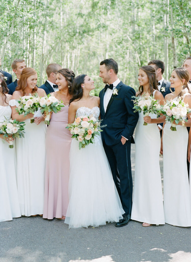 tented-wedding bride and groom standing with their wedding party during their outdoor wedding in New England
