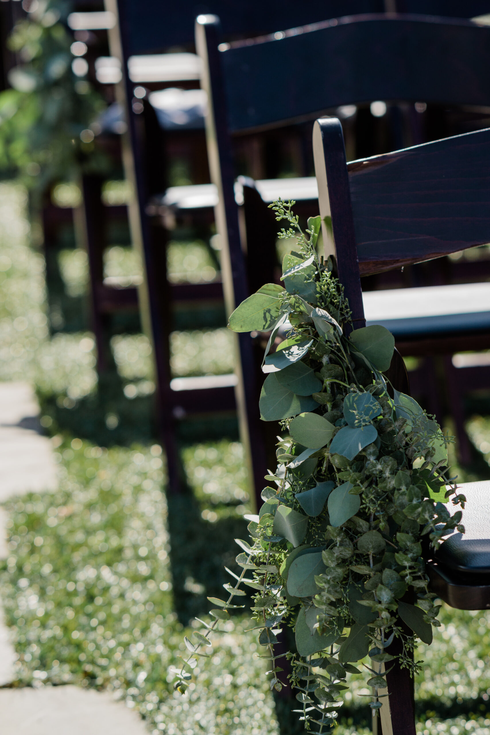 tented-wedding floral details on the ceremony chairs during an outdoor wedding in New England