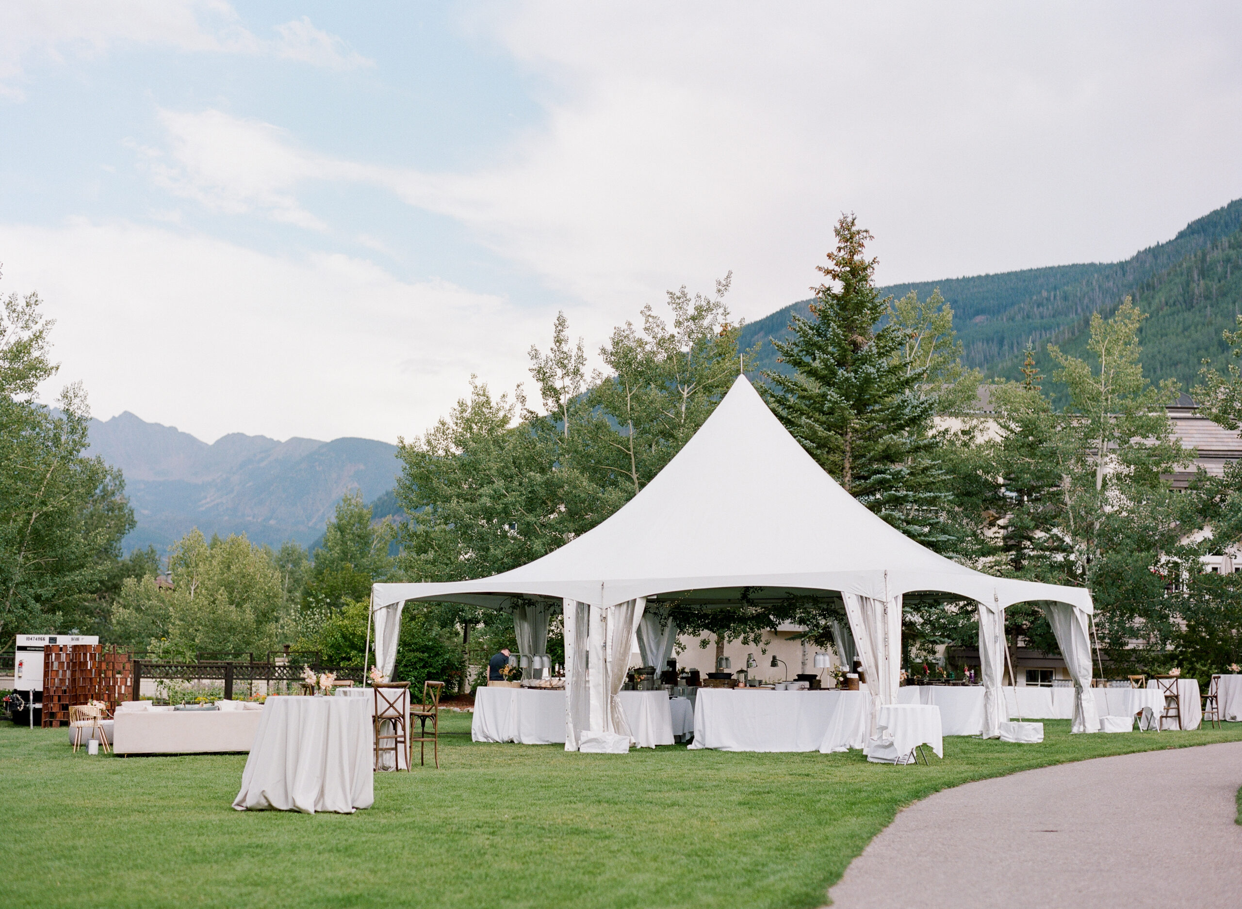 tented-wedding Elegant white tented wedding setup nestled in scenic mountain landscape.