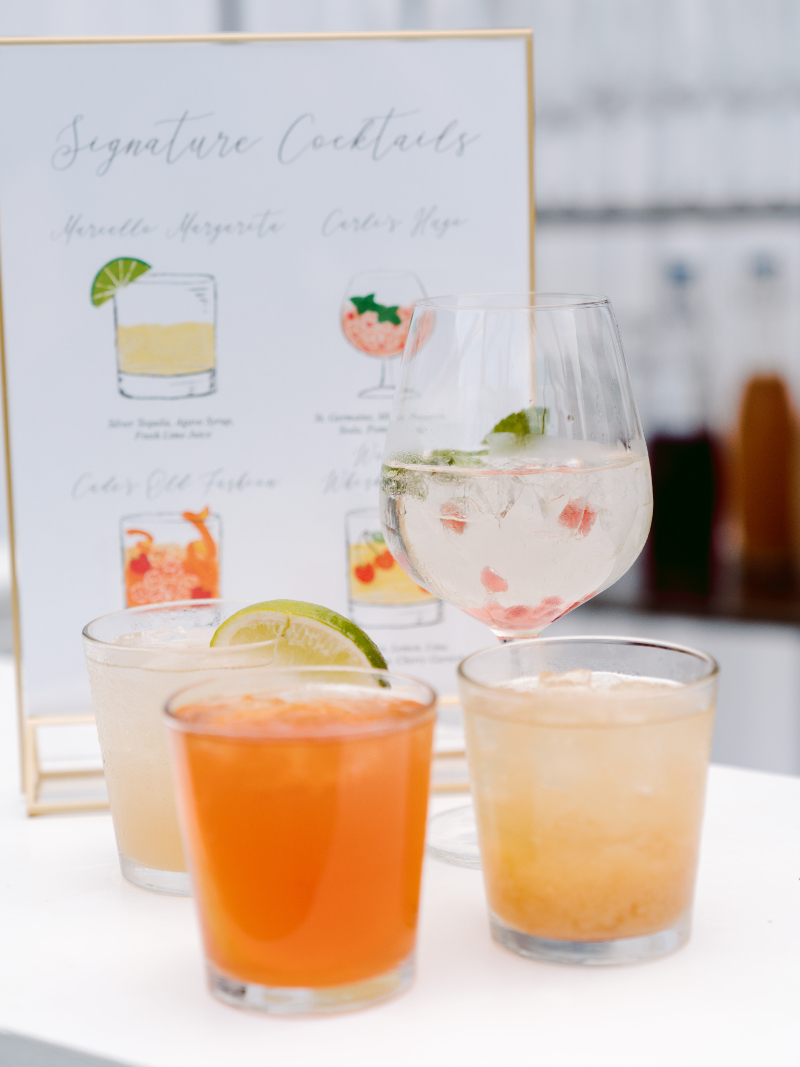 Signature wedding cocktails creatively styled by the wedding planner, featuring custom drink signage and garnishes.