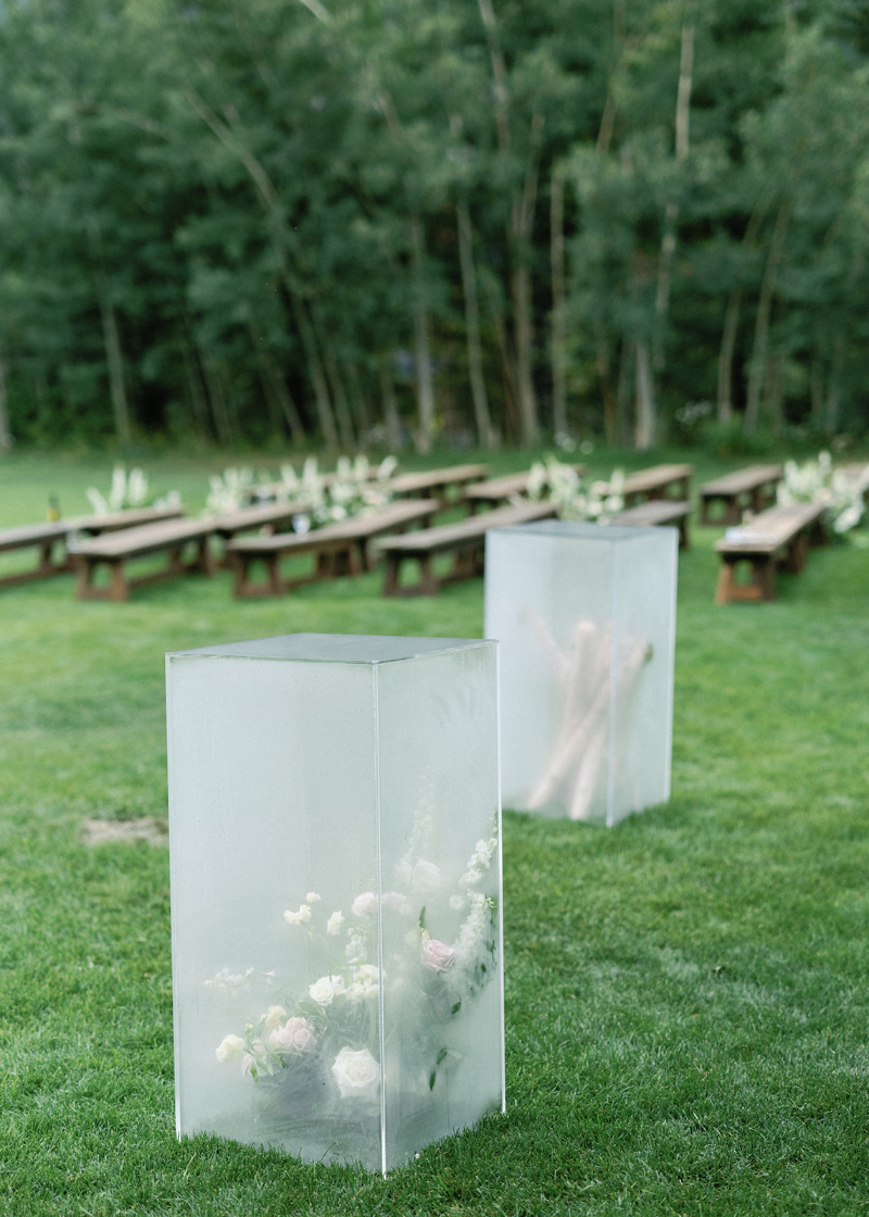 Acrylic columns with florals and birch branches offer modern, nature-inspired wedding design ideas for ceremonies.