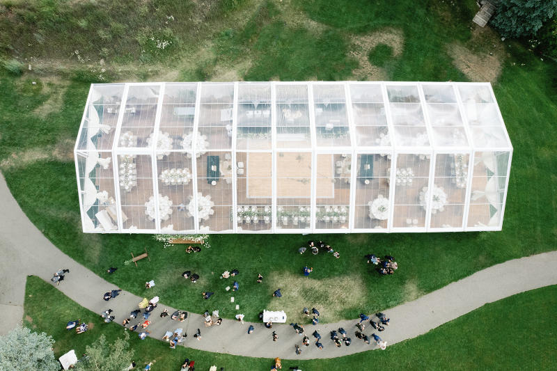 Aerial view of a clear-top tent wedding in Colorado with elegant tables and central dance floor.