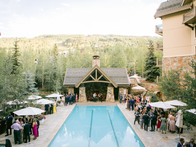 Guests gather poolside in the mountains during welcome party for luxury multi-day wedding experiences.