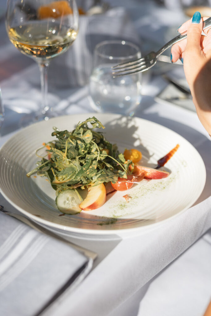 Seasonal salad served at an outdoor welcome dinner during luxury multi-day wedding experiences.