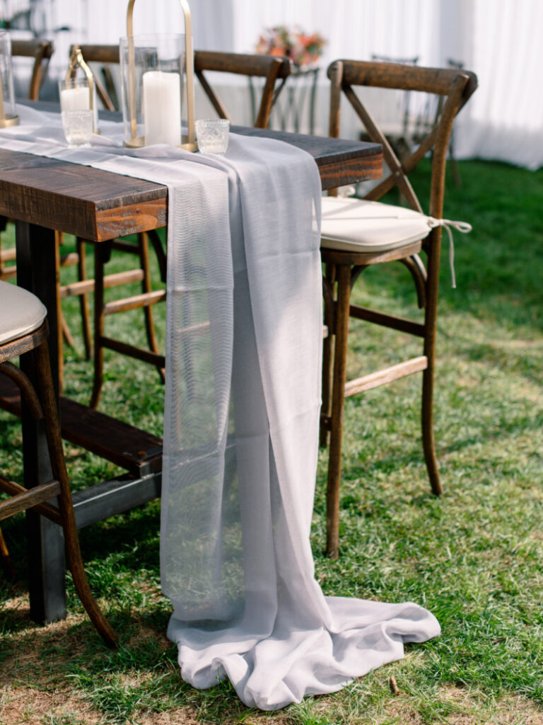 Elegant estate reception table styled through full-service wedding planning with layered linens and candlelight.