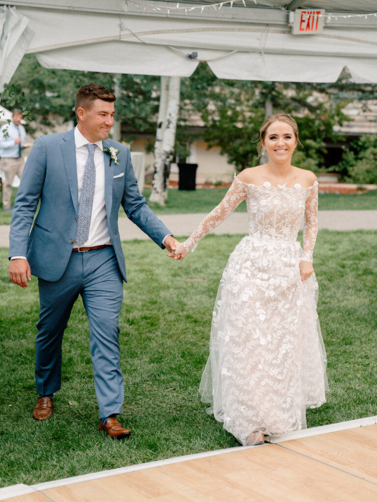 Bride and groom walking on estate lawn, guided by full-service wedding planning expertise.