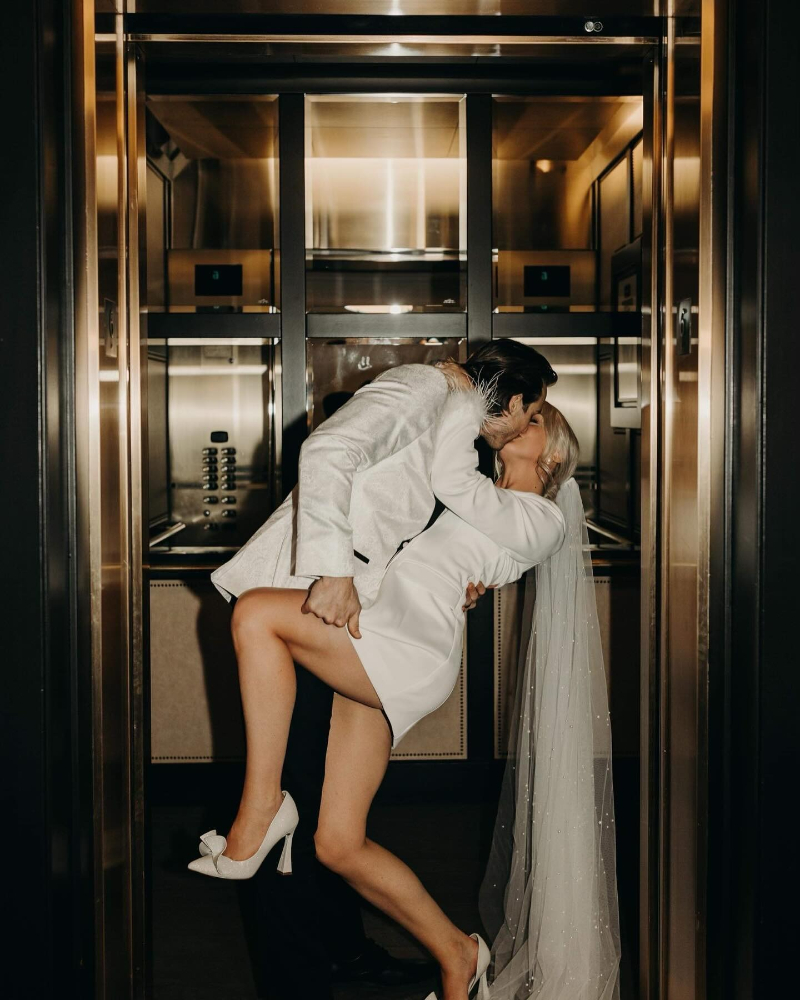 Romantic reception moment with couple sharing an intimate embrace in a softly lit, elegant interior setting