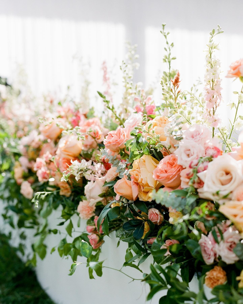 Boston wedding planner floral installation with soft peach and blush blooms for elegant ceremony design