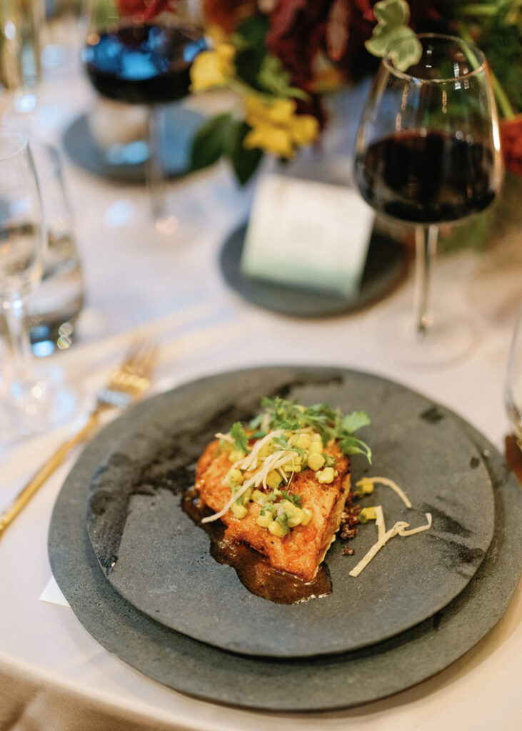 Plated wedding dinner featuring seared salmon and fresh garnish at a New England wedding reception.