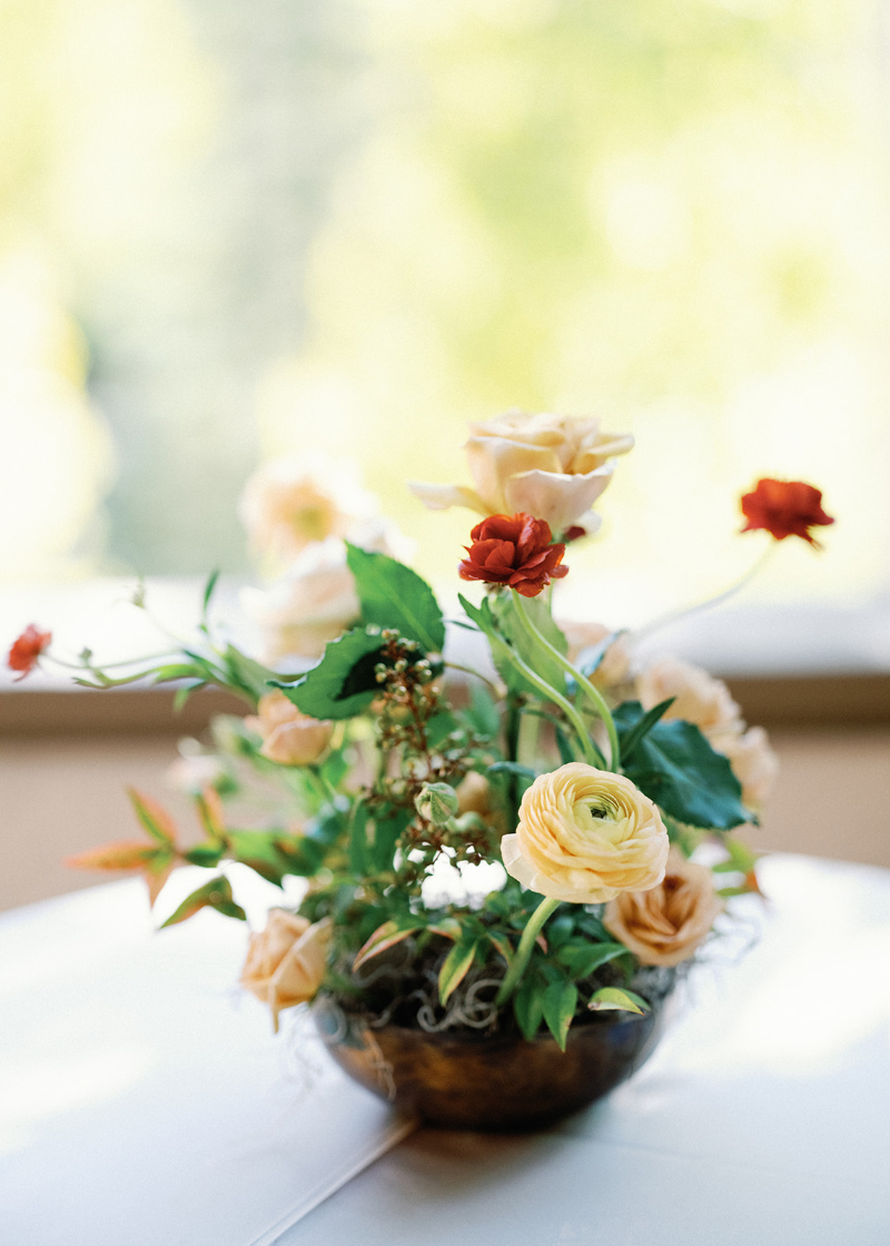 Floral centerpiece with cream and peach blooms, styled by a New England wedding planner for reception design.