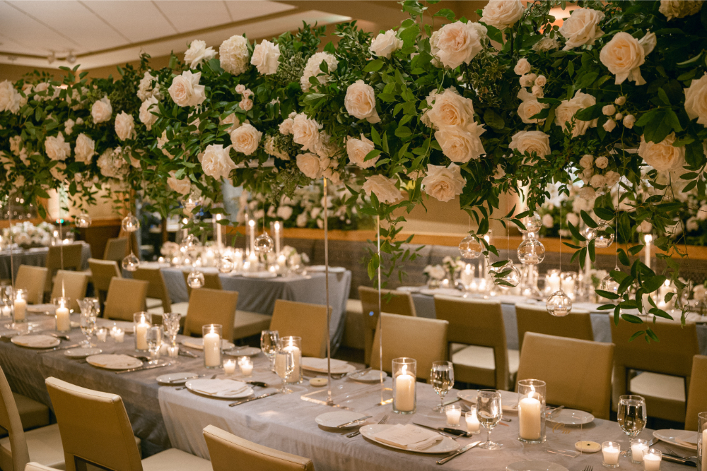 Wedding reception tables with floral arrangements, candles, and place settings